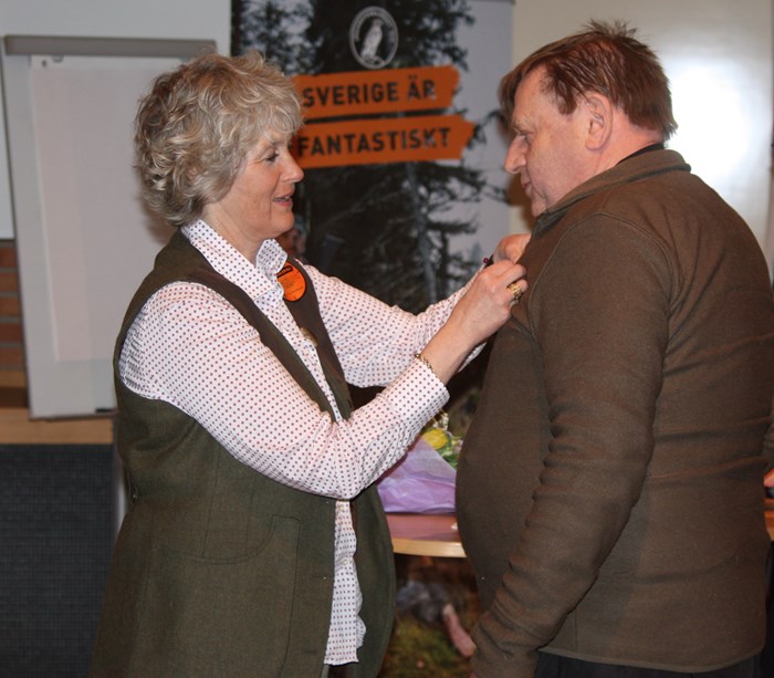 Helené Sterner fäster utmärkelsen på Calle Ekström
